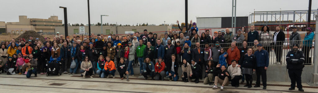 A large crowd of individuals posing for a photo at an LRT station.